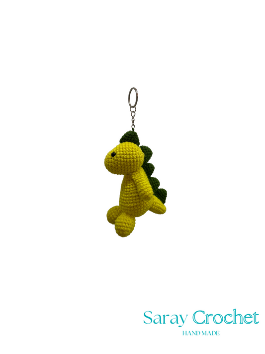 Crocheted dinosaur keychain on a white background with 'Saray Crochet' branding.