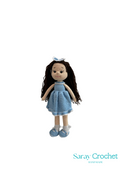 Handmade doll with long brown hair, wearing a blue dress and shoes, standing against a white background with the text 'Saray Crochet'.