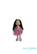 Handmade crochet doll with long brown hair, wearing a classic pink dress and shoes, with the brand name 'Saray Crochet' visible.
