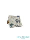 Folded fabric with hot air balloon pattern on a white background, branded 'Saray Crochet'.