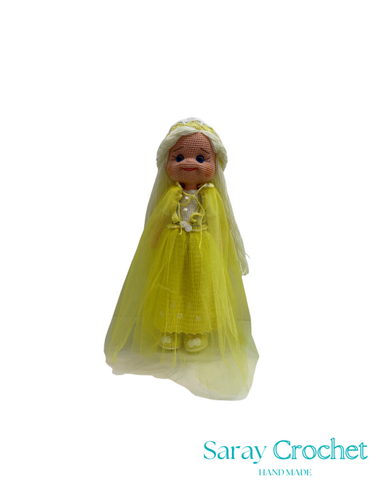 Toy doll with a yellow outfit on a white background, branded 'Saray Crochet'.