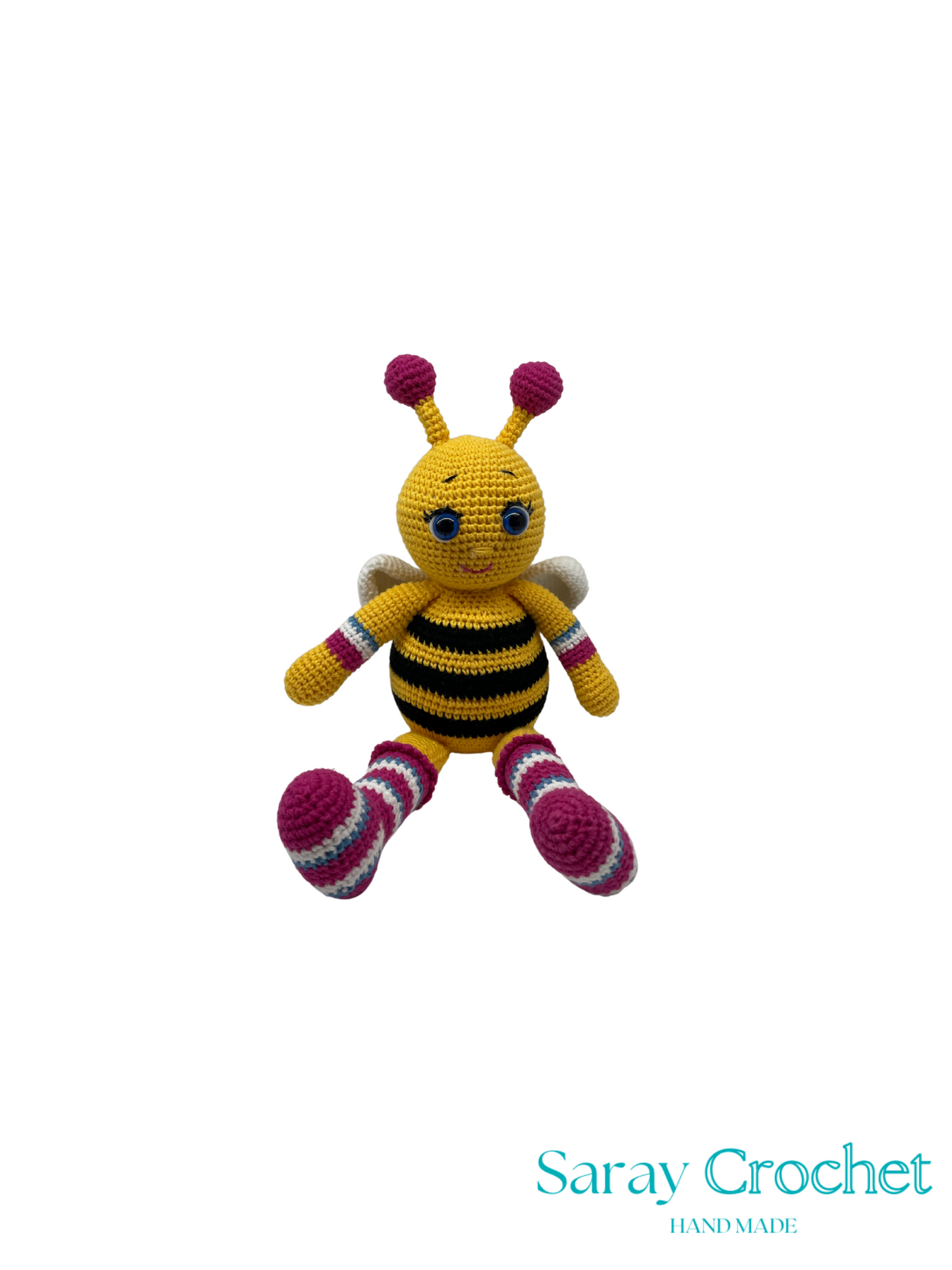 Crocheted bee toy with yellow body, black stripes, and pink accents on a white background. Brand 'Saray Crochet' visible.