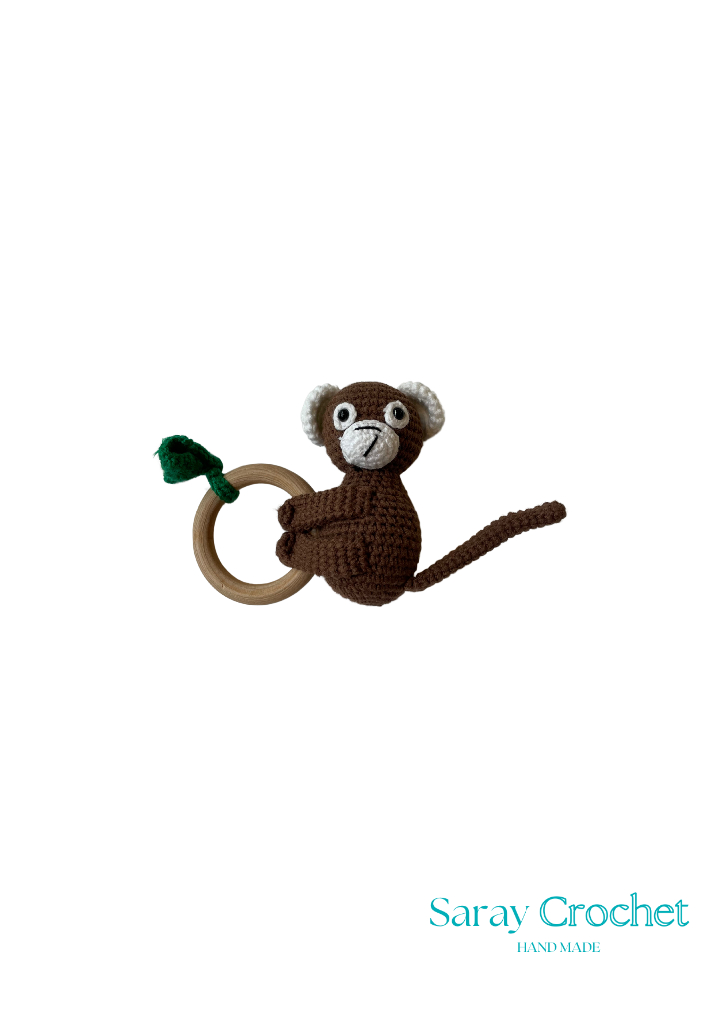 A crochet toy in the shape of a brown monkey with a green tail, hanging from a ring.