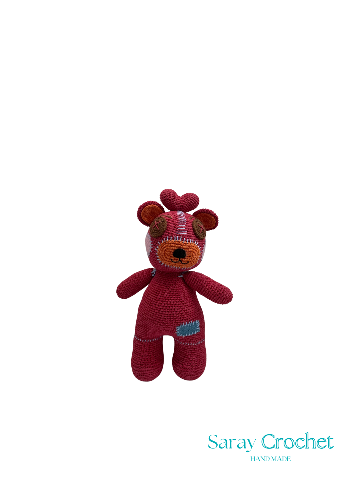 Handmade plush toy resembling a cartoon character with red and pink colors, featuring a heart on its chest and the brand name 'Saray Crochet'.