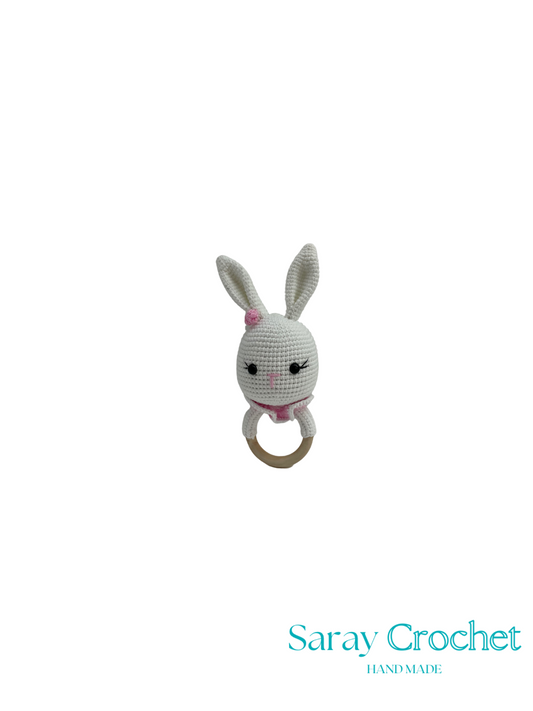 Crocheted bunny rattle with pink bow on a white background, branded 'Saray Crochet'.