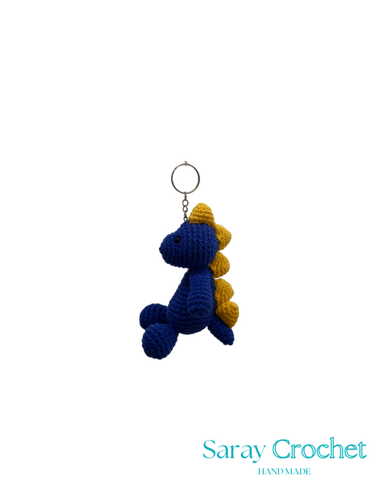 Crocheted dragon keychain with blue and yellow colors on a white background, branded 'Saray Crochet'.