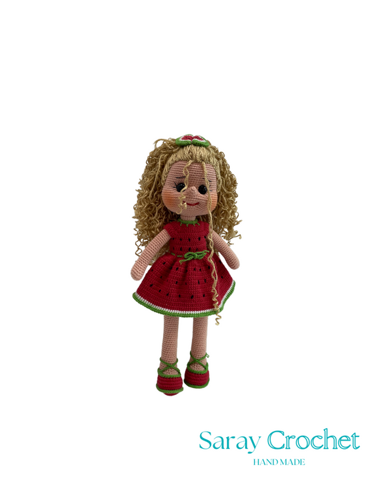 Handmade doll with red dress and curly hair on a white background, branded 'Saray Crochet'.