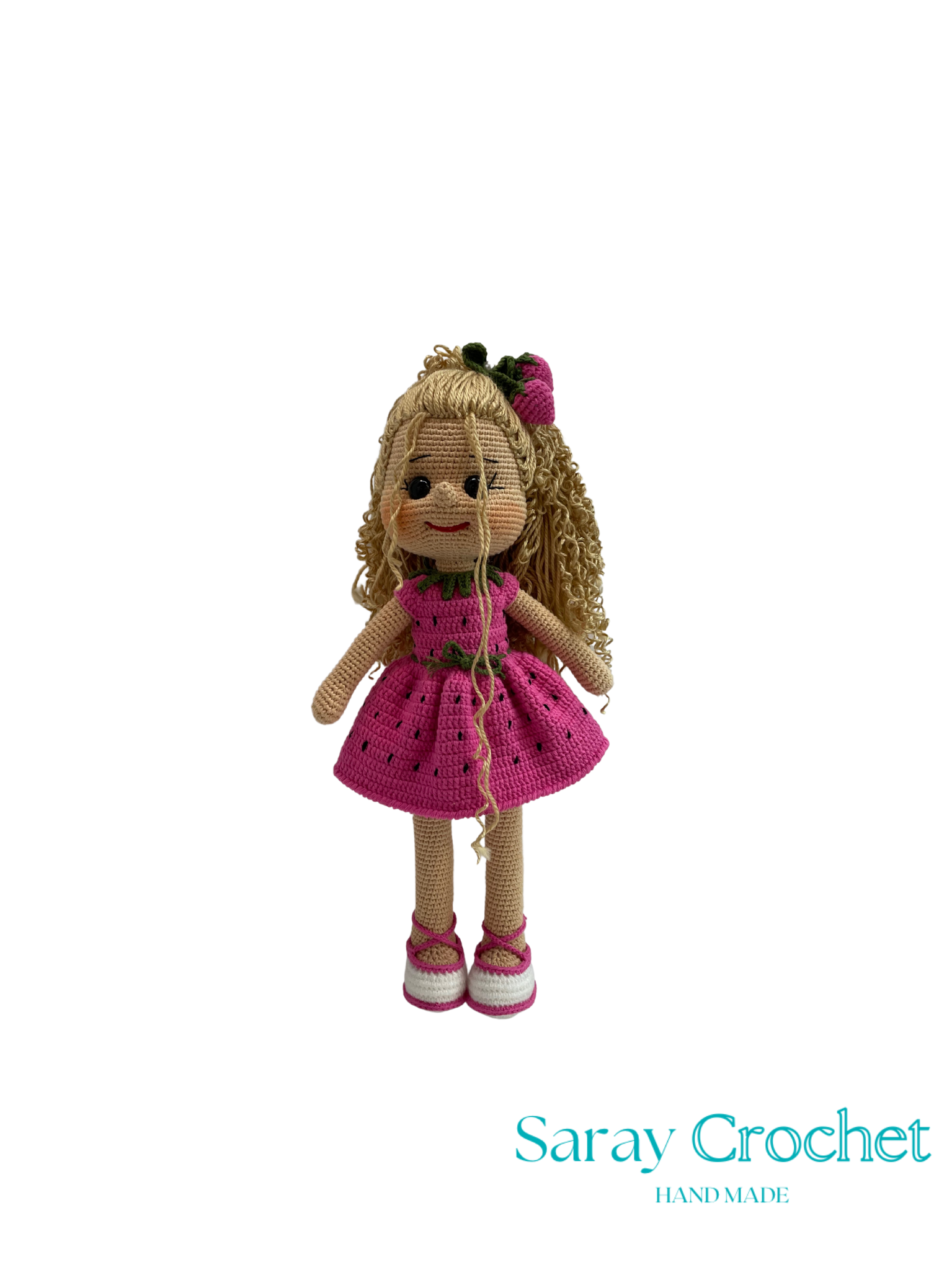 Handmade doll with blonde hair and a pink dress on a white background, branded 'Saray Crochet'.