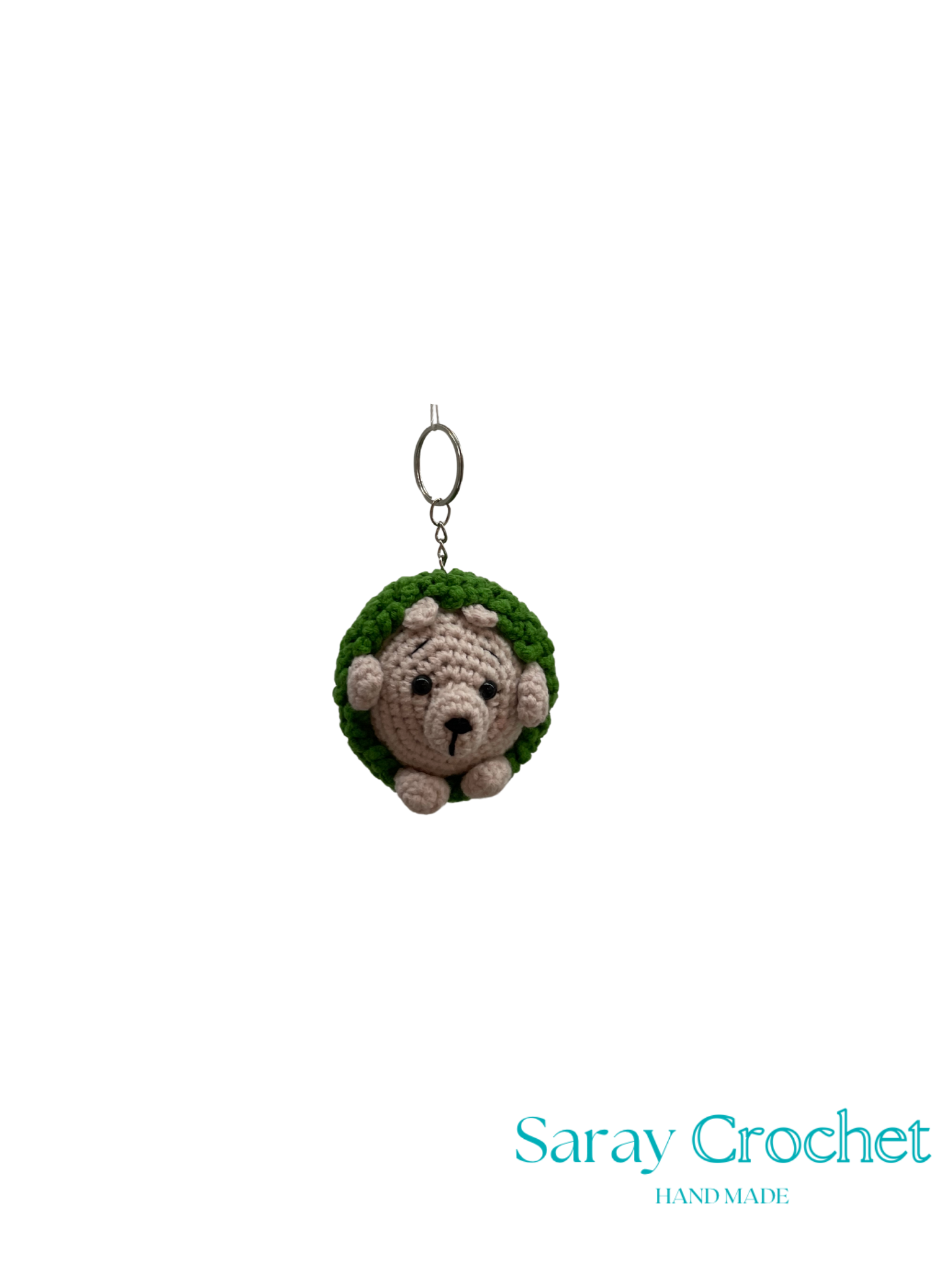 Crocheted hedgehog keychain with a green top on a white background, branded 'Saray Crochet'.