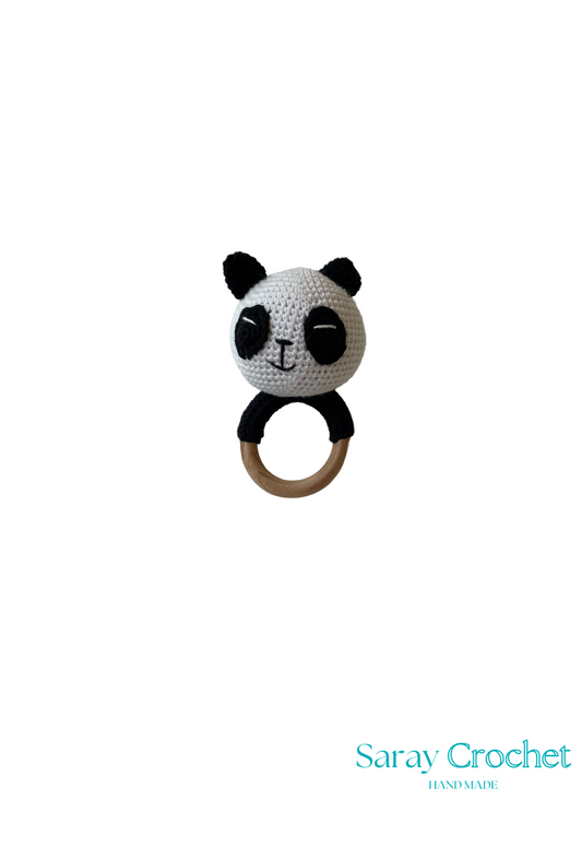 A crochet stuffed toy in the shape of a panda with a black and white design, featuring a ring for holding.