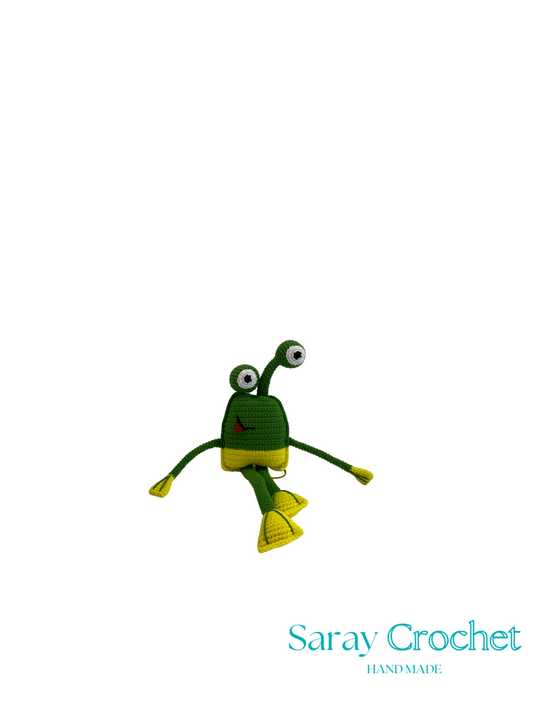 Crocheted frog toy with 'Saray Crochet' branding on a white background