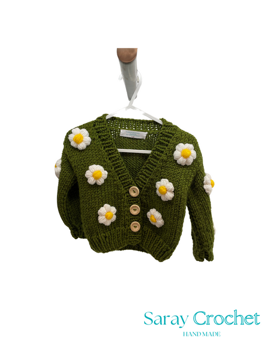 Green knitted cardigan with flower decorations on a white background, branded 'Saray Crochet'.
