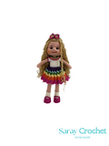 Knitted doll with colorful dress and hairband on a white background, branded 'Saray Crochet'.