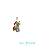 Crocheted unicorn keychain with colorful hair on a white background, branded 'Saray Crochet'.