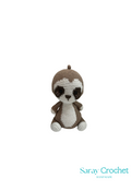 A beige plush toy resembling a sloth with a brown hat, made by Saray Crochet.