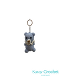 Crocheted bear keychain with a gold ring on a white background, branded 'Saray Crochet'.