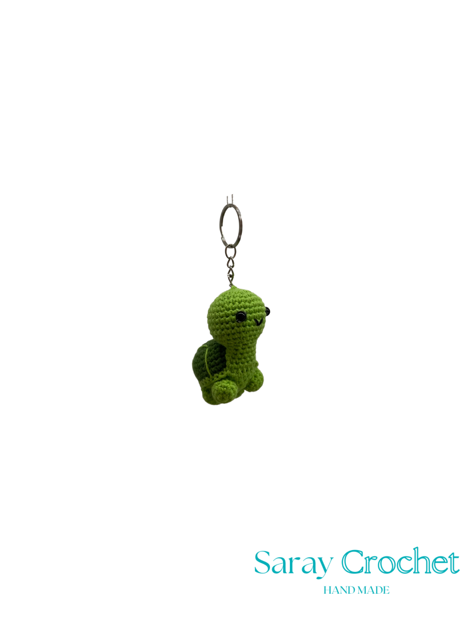 Green crocheted turtle keychain on a white background with 'Saray Crochet' branding.