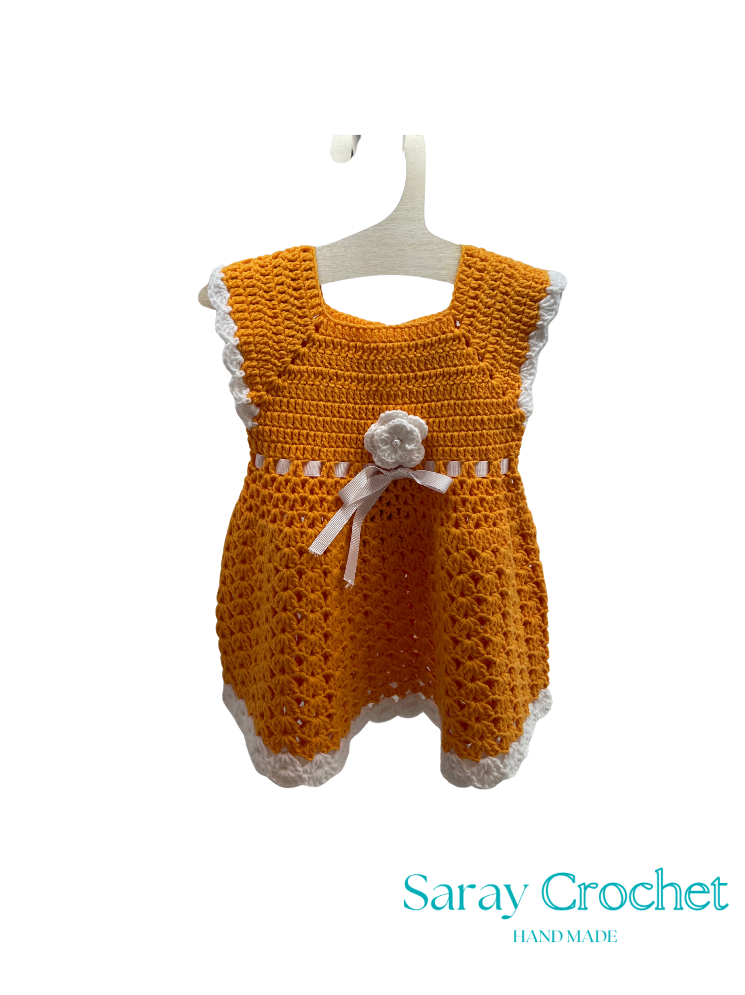 Crocheted baby dress with white trim on a hanger, branded 'Saray Crochet'.
