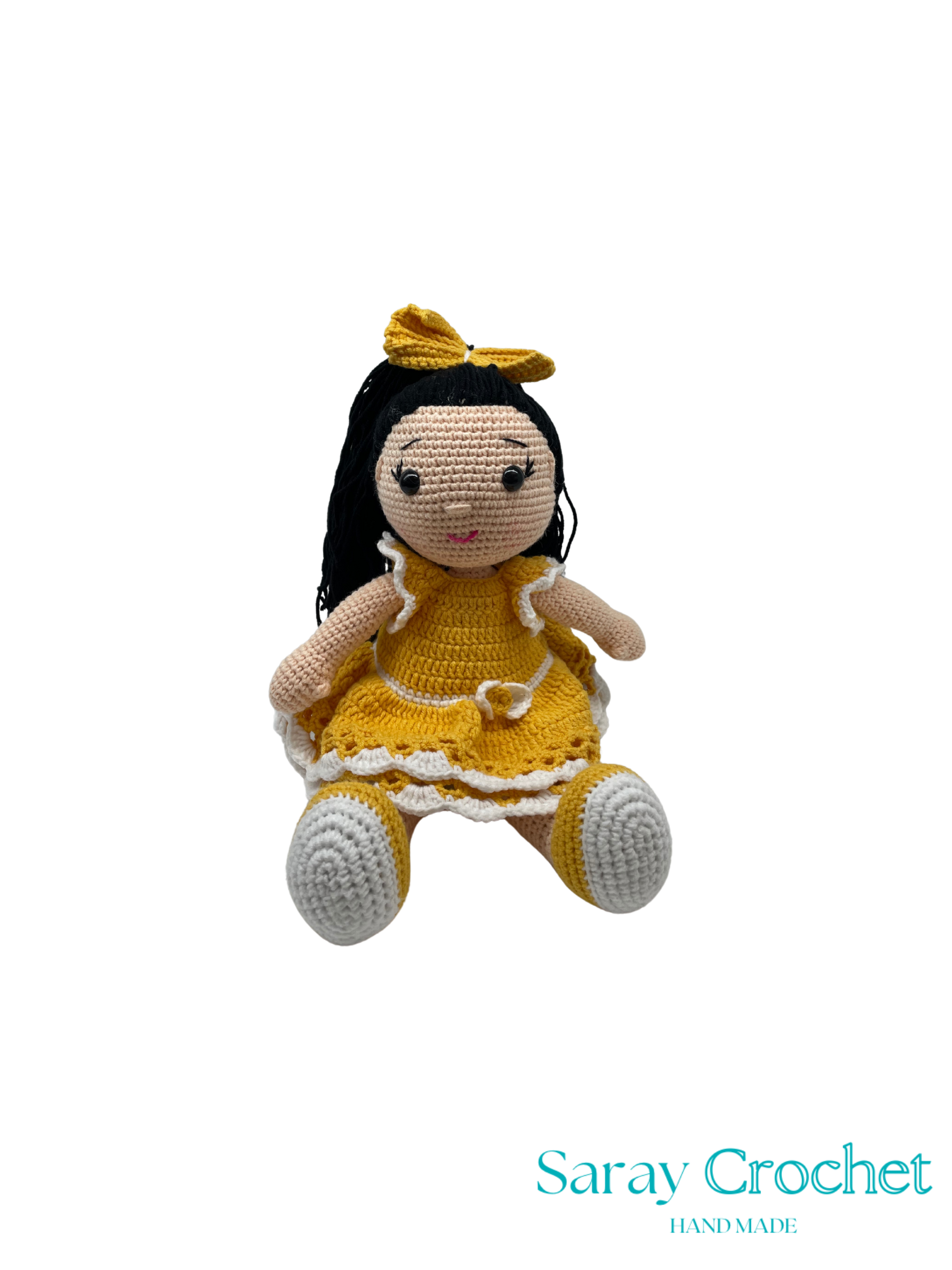 Crocheted doll with yellow dress and bow on a white background, branded 'Saray Crochet'.