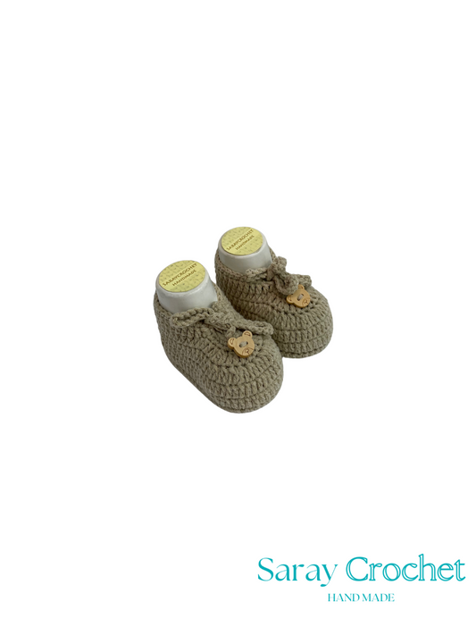 Pair of crocheted baby booties with a white background and 'Saray Crochet' branding.