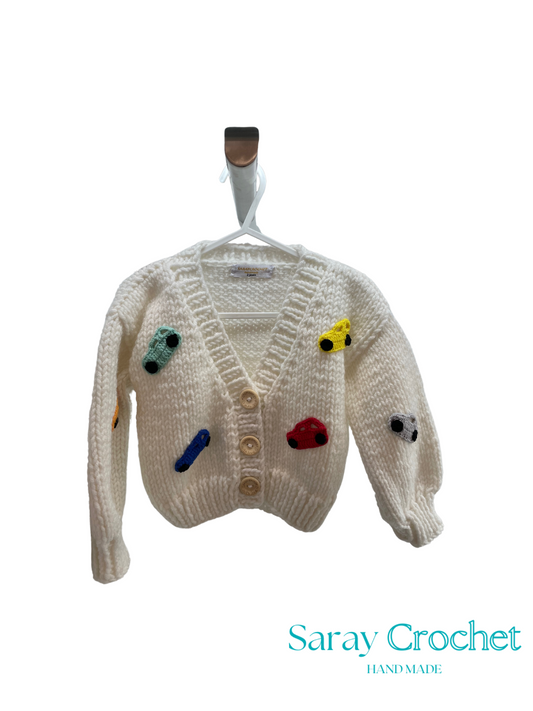 Knitted cardigan with colorful buttons on a hanger, branded 'Saray Crochet'.