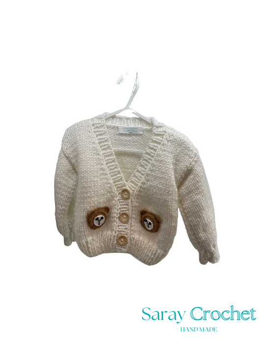 Knitted children's cardigan with bear face design on a hanger, branded 'Saray Crochet'.