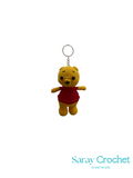 Crocheted bear keychain with red sweater on a white background, branded 'Saray Crochet'.