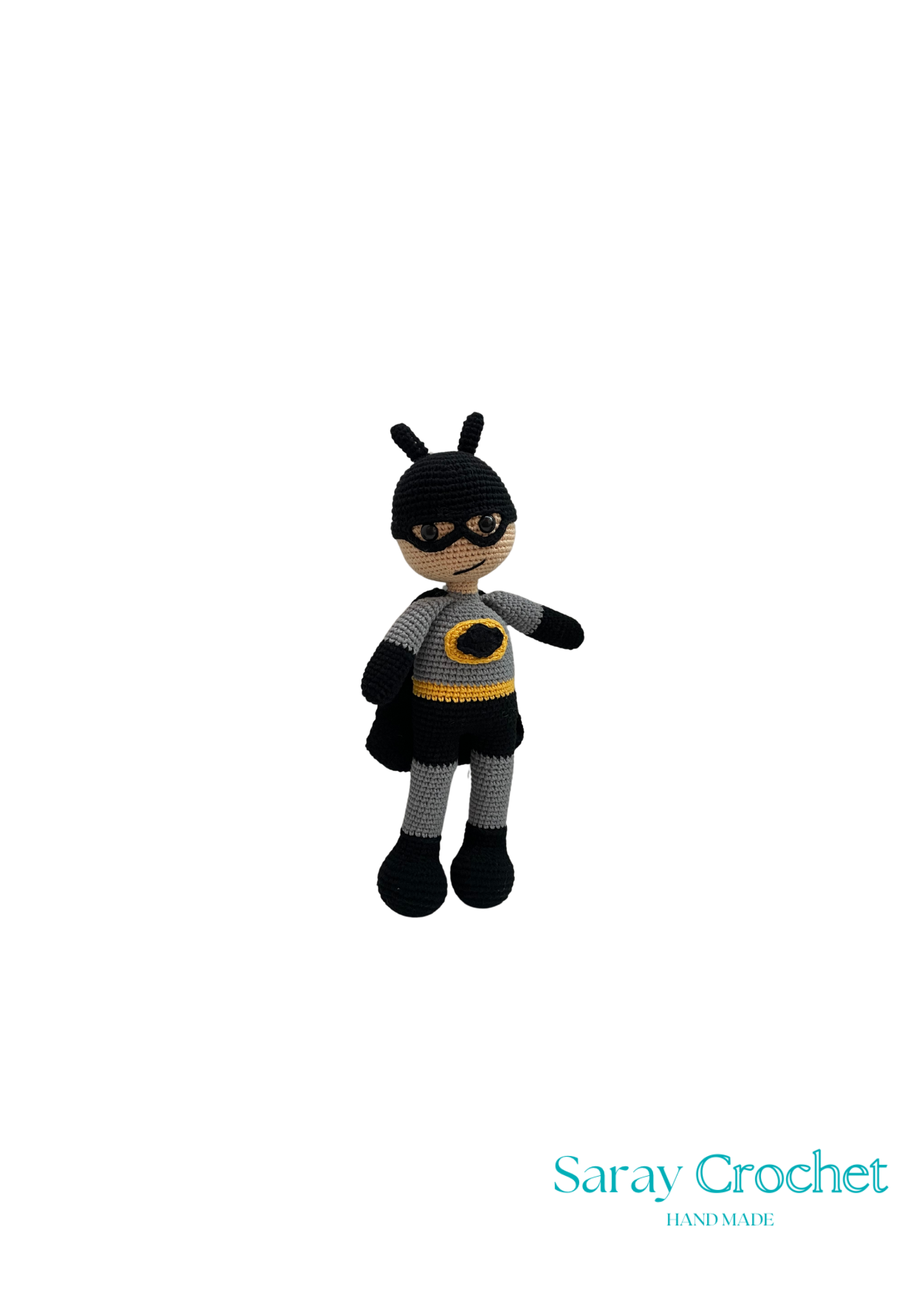 A crochet doll resembling Batman, with a black and yellow outfit and a batman mask.