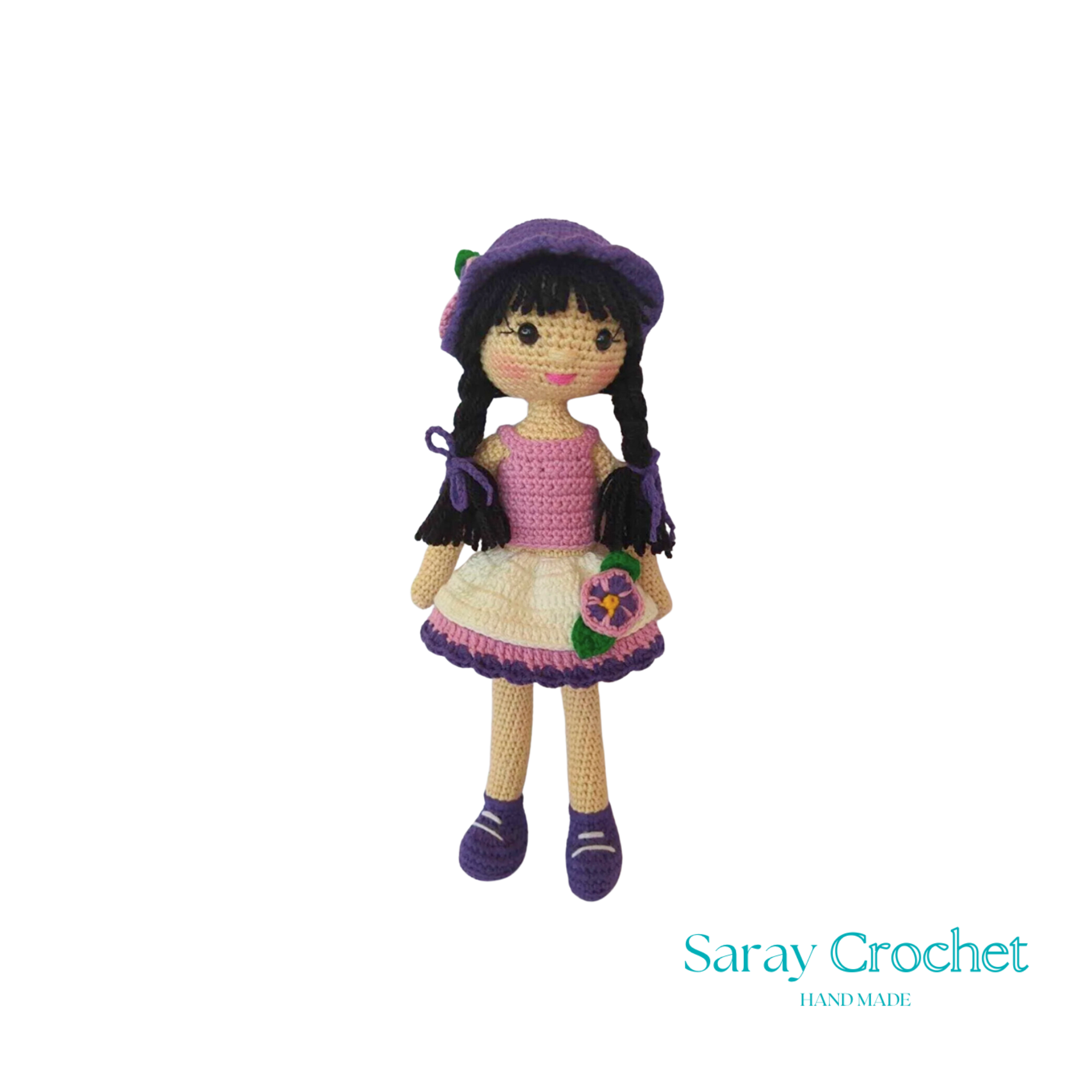 Handmade crochet doll with a pink dress, white details, and a purple hat.