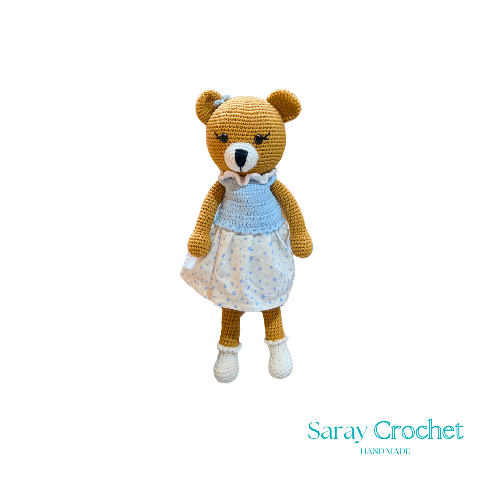 Handmade plush toy resembling a bear with a blue dress and white shoes, on a white background.