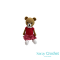 Crocheted teddy bear with a red dress on a white background, branded 'Saray Crochet'.