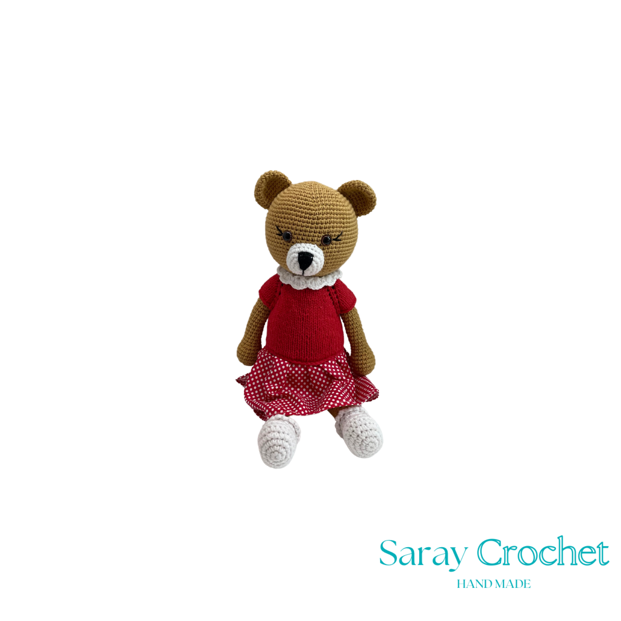 Crocheted teddy bear with a red dress on a white background, branded 'Saray Crochet'.