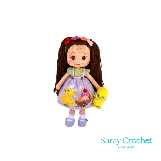Handmade doll with a floral dress and a fluffy bow in her hair, holding a small yellow bird, with a soft color palette.