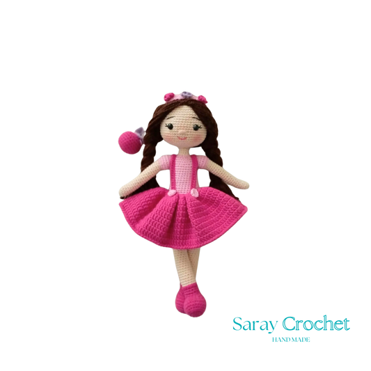 A handcrafted doll with a pink and white outfit, featuring a floral headband and matching shoes.