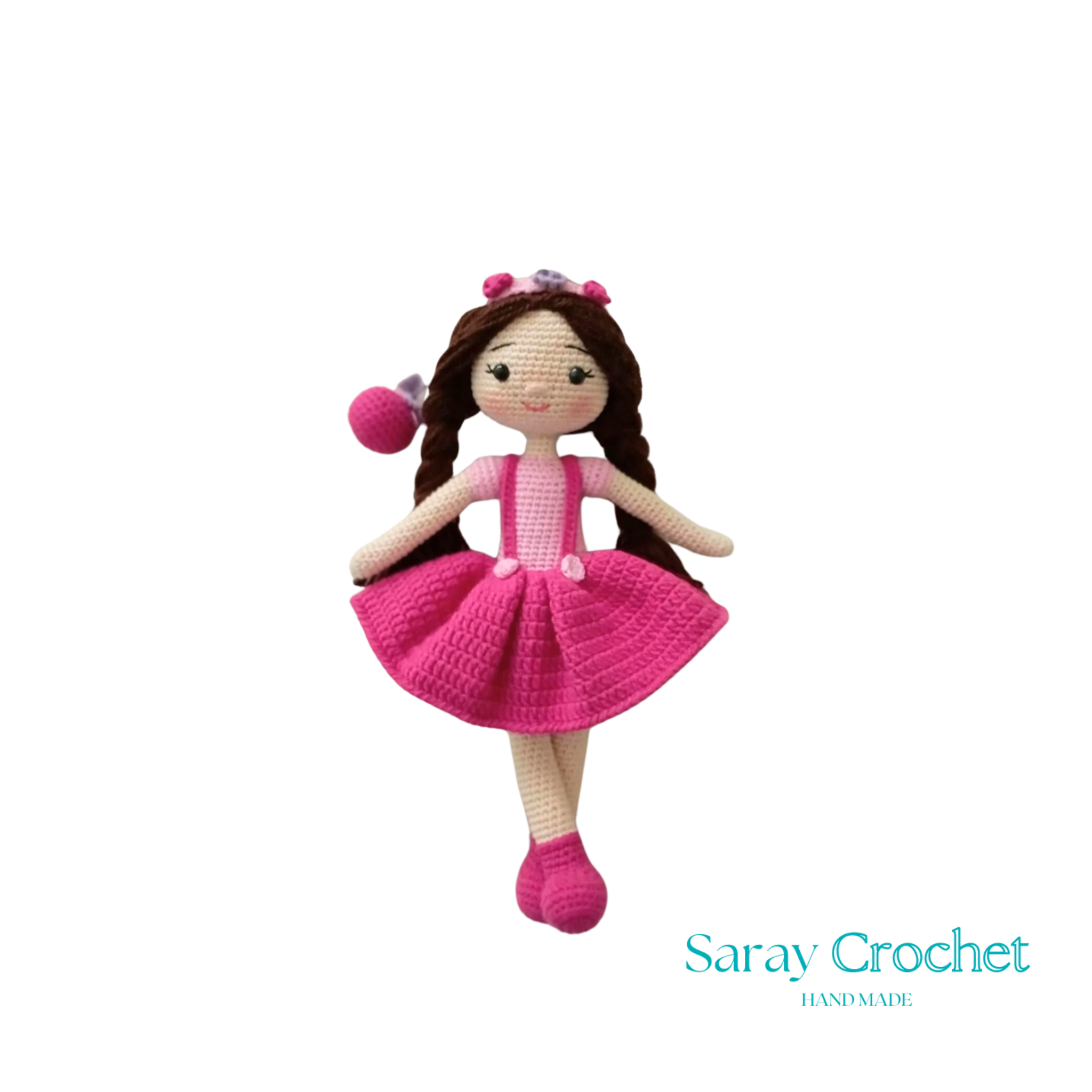 A handcrafted doll with a pink and white outfit, featuring a floral headband and matching shoes.
