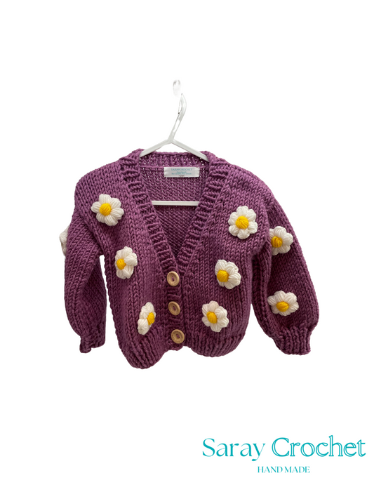 Purple children's cardigan with flower decorations on a white background, branded 'Saray Crochet'.