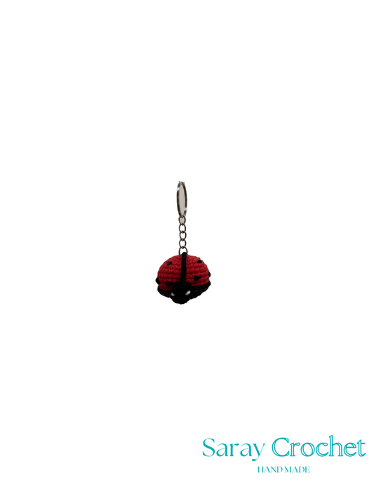 Red and black ladybug charm on a white background with 'Saray Crochet' branding.